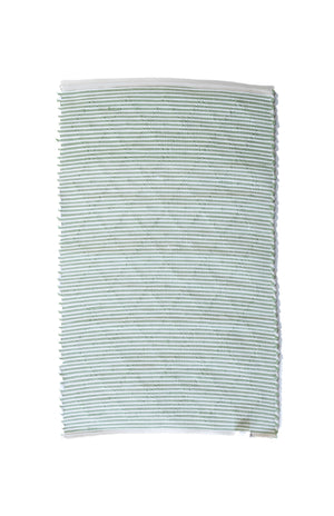 the reverse side of a cotton green accent rug 