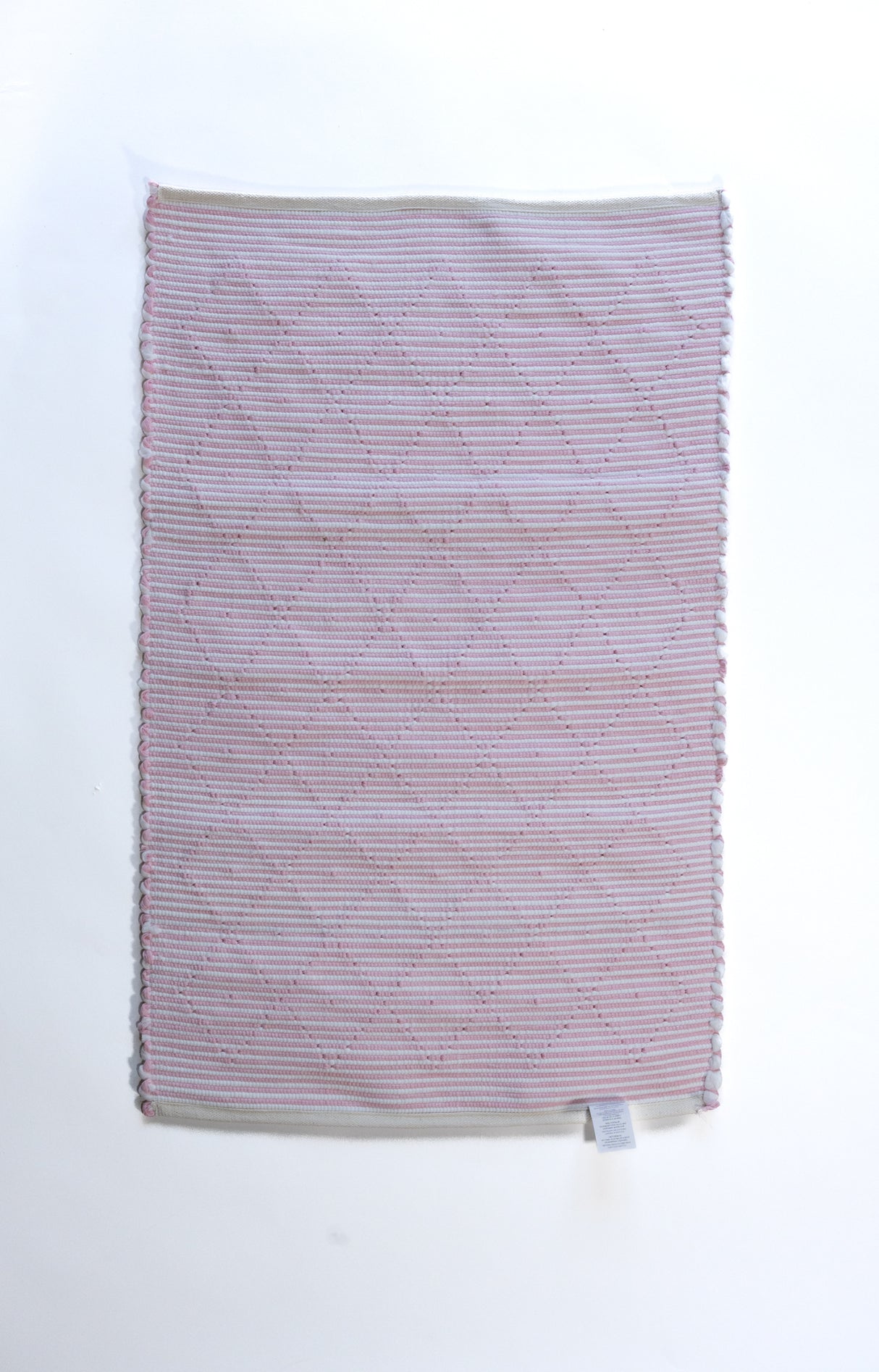 The plain reverse side of a pink accent rug from madcap cottage