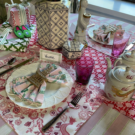 Tablescape of East of the Sun red chinoiserie placemat with Asian themed porcelainware.