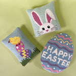 Assorted Easter hooked pillows featuring bunnies, chicks, carrots, eggs, and spring floral designs