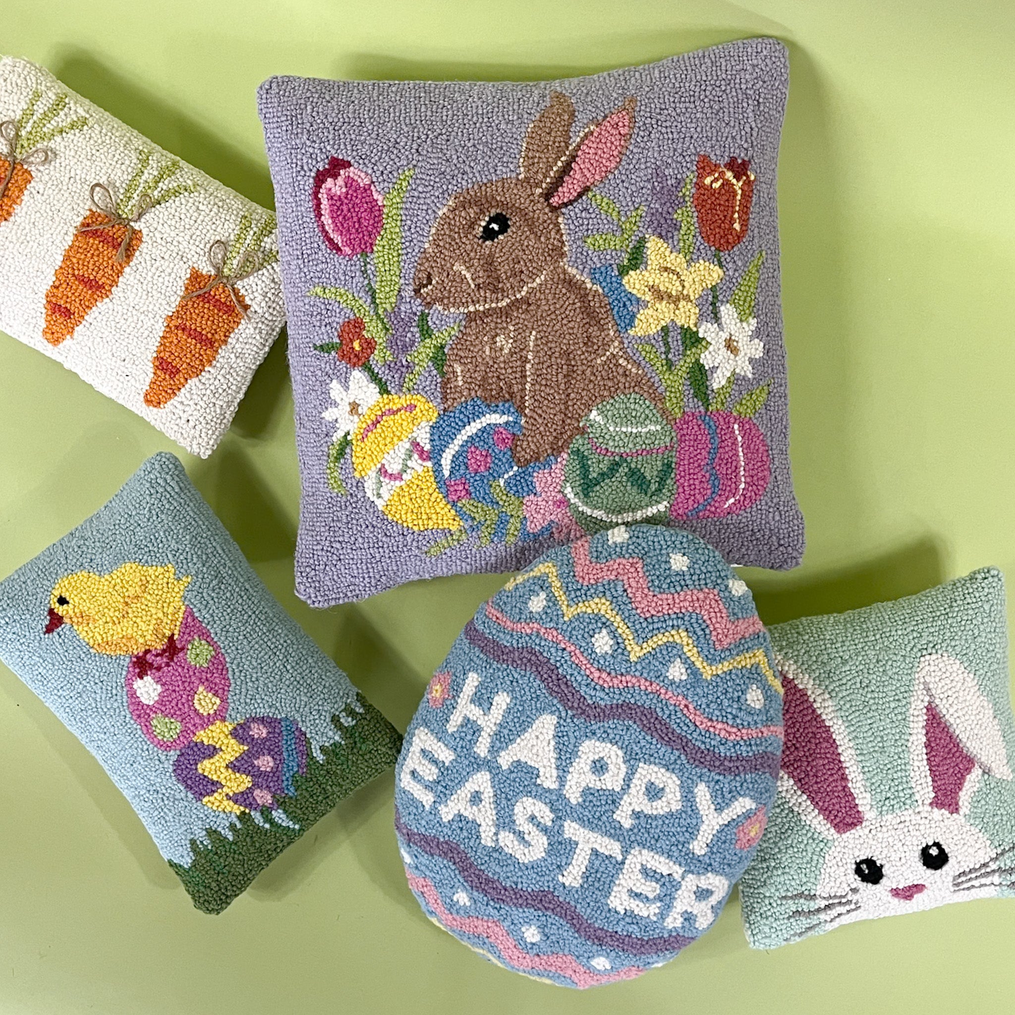 Assorted Easter hooked pillows featuring bunnies, chicks, carrots, eggs, and spring floral designs