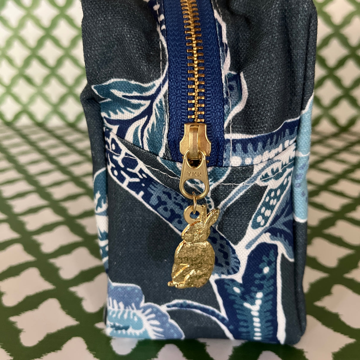 End view of Temple Garden toiletry bag in navy blue features light blue floral motif.