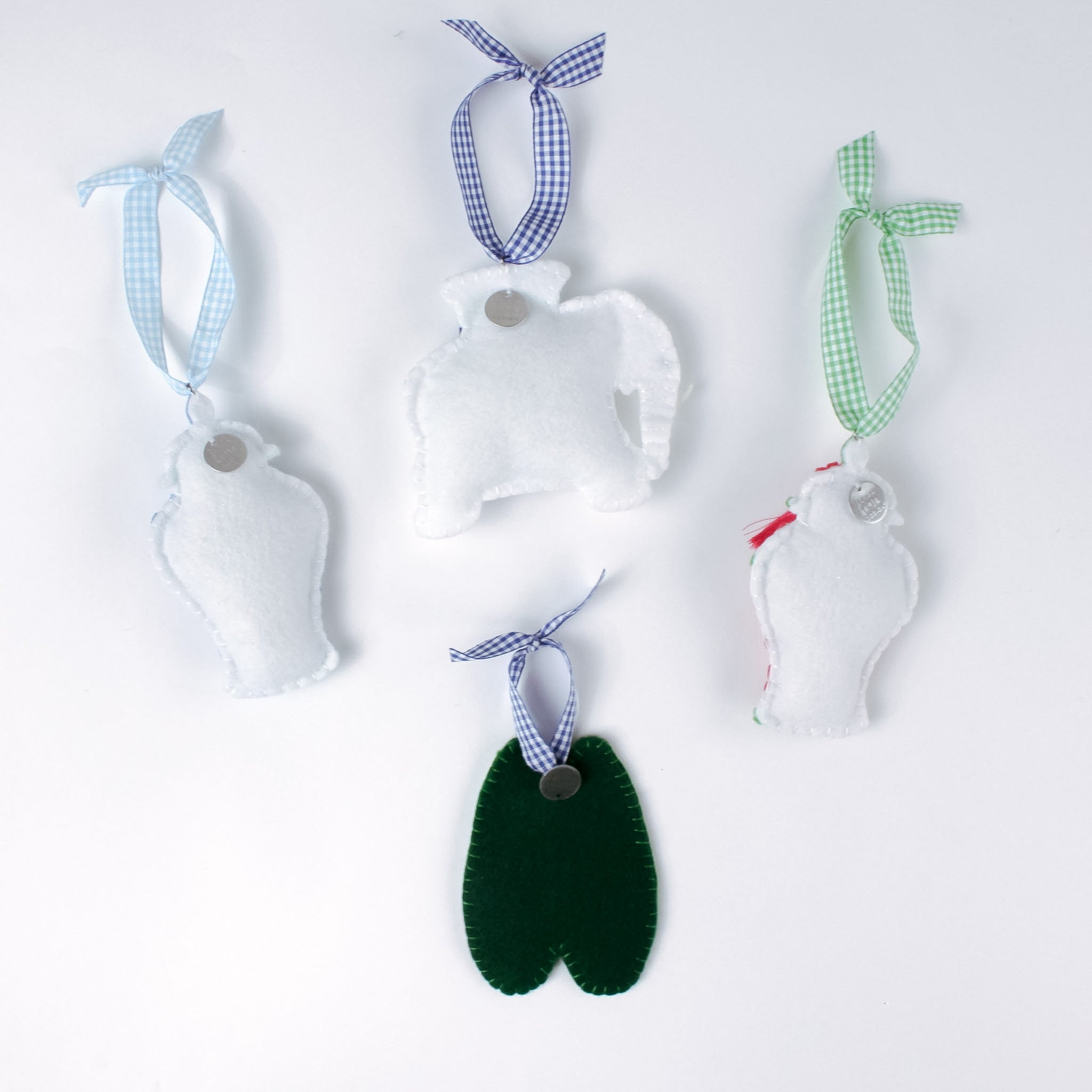 back of felt chinoiserie Christmas ornaments including a blue ginger jar, red ginger jar green loafers, and elephant on a white background.