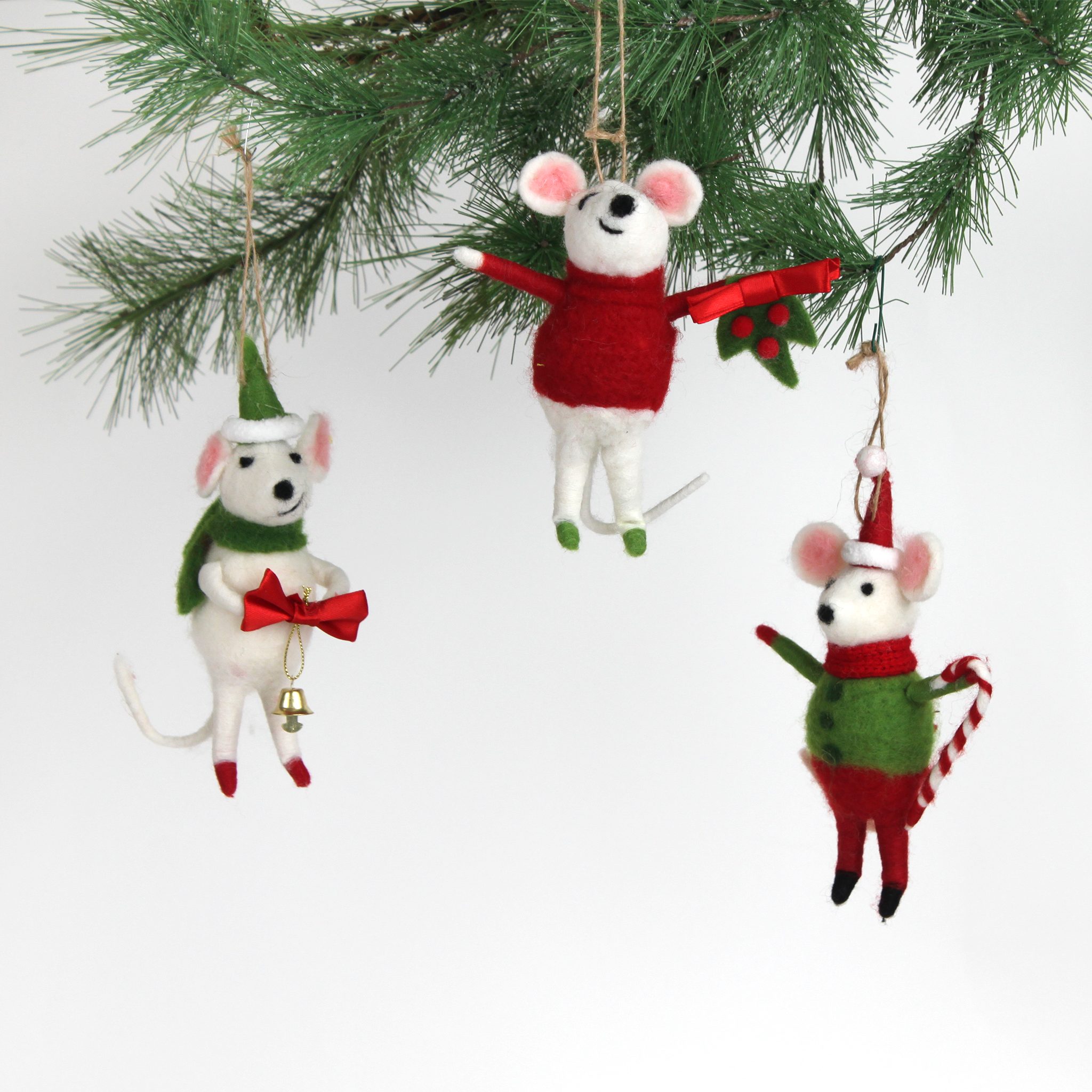 Three festive felt mouse ornaments dressed in holiday outfits hanging in a christmas tree