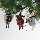 Three festive felt mouse ornaments dressed in fuzzy holiday outfits and Santa hats, holding Christmas decorations like string lights, a wreath, and a gold bell.