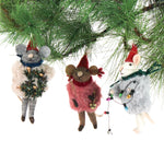 Three festive felt mouse ornaments dressed in fuzzy holiday outfits and Santa hats, holding Christmas decorations like string lights, a wreath, and a gold bell.