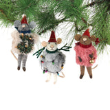 Three festive felt mouse ornaments dressed in fuzzy holiday outfits and Santa hats, holding Christmas decorations like string lights, a wreath, and a gold bell.