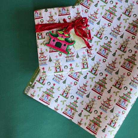 colorful Christmas wrapping paper featuring pagoda, holly and wreath motifs. 