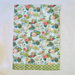 Floral tea towel featuring water lily and herom motifs