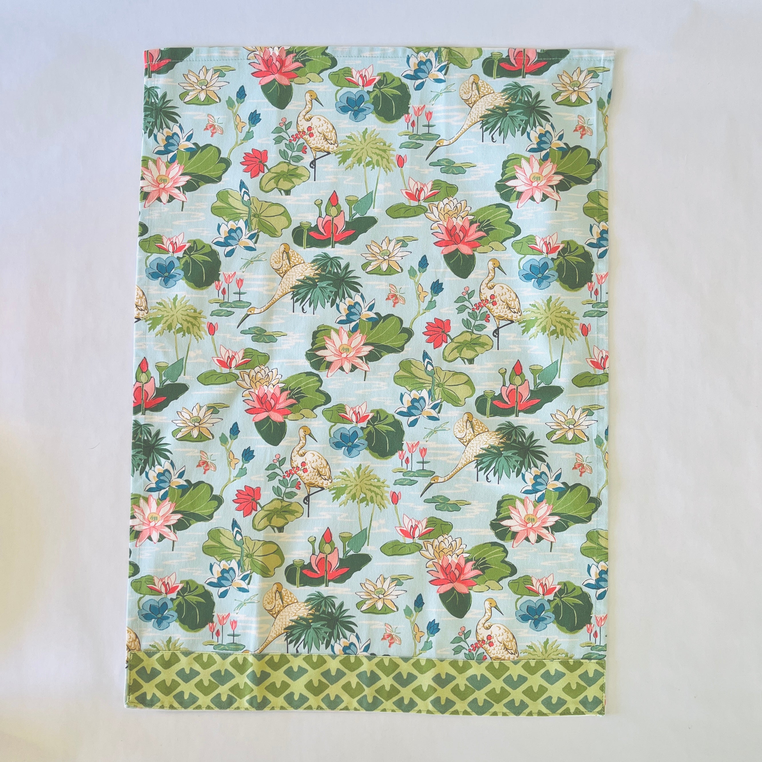 Floral tea towel featuring water lily and herom motifs