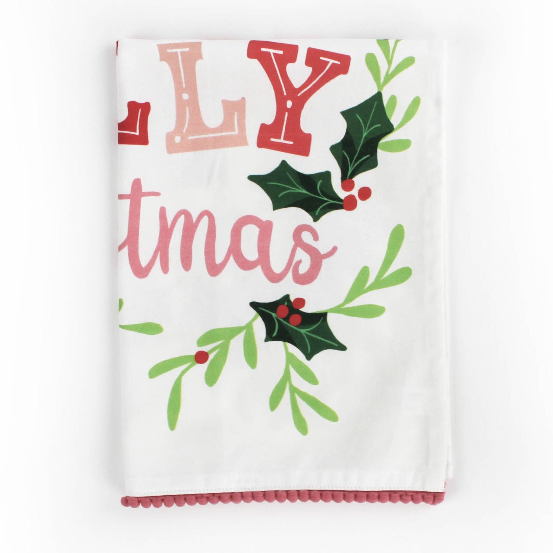 A folded Christmas tea towel with holly motifs and text that reads Holly Jolly Christmas