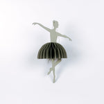 Decorative ballerina christmas ornament with a green skirt on a white background