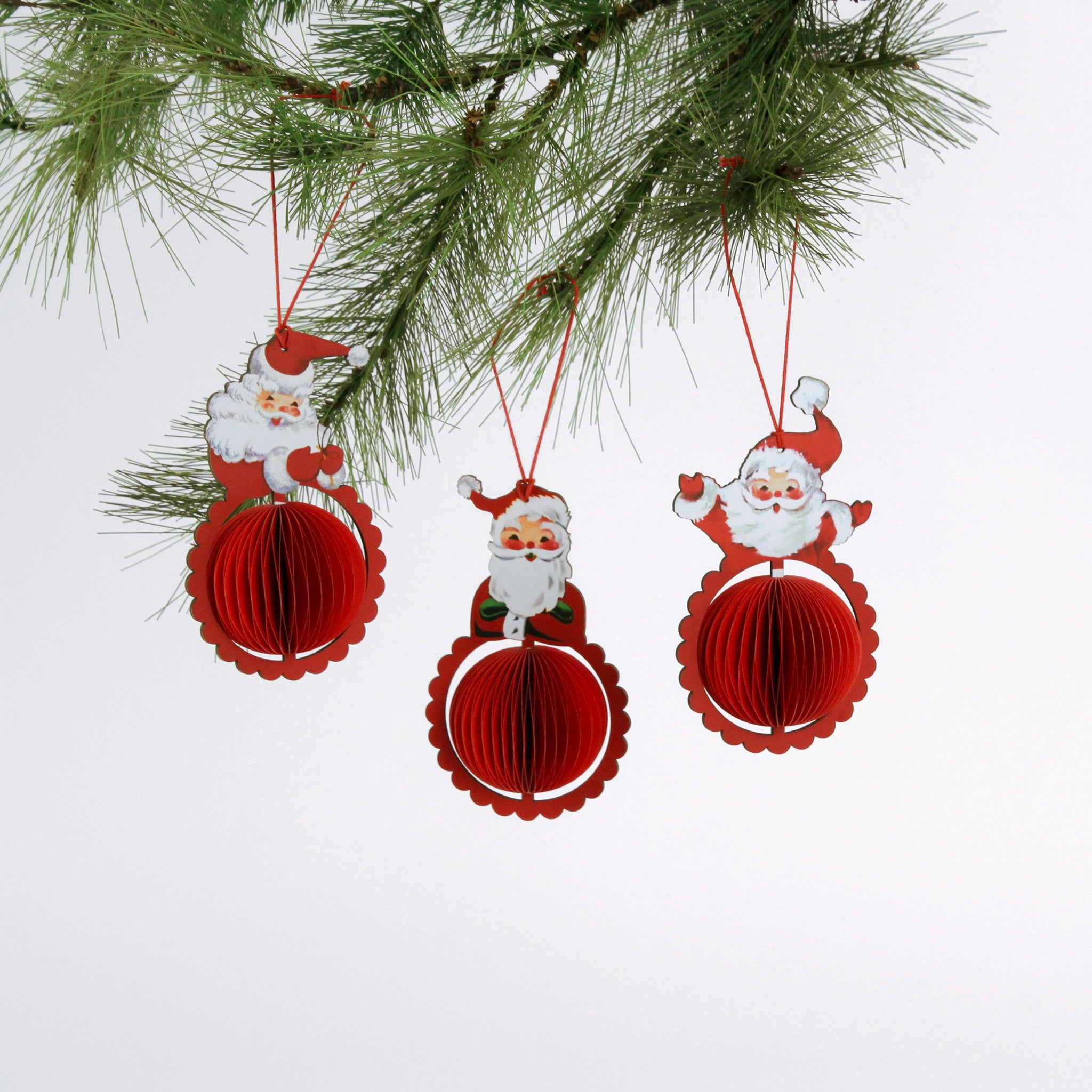 Set of three folding paper Santa Christmas ornaments in vibrant red with honeycomb-style bases