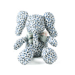 Blue and white patterned stuffed elephant toy with a green bow.