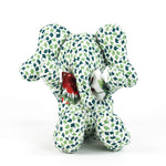 Green and white patterned stuffed elephant toy with a red bow.