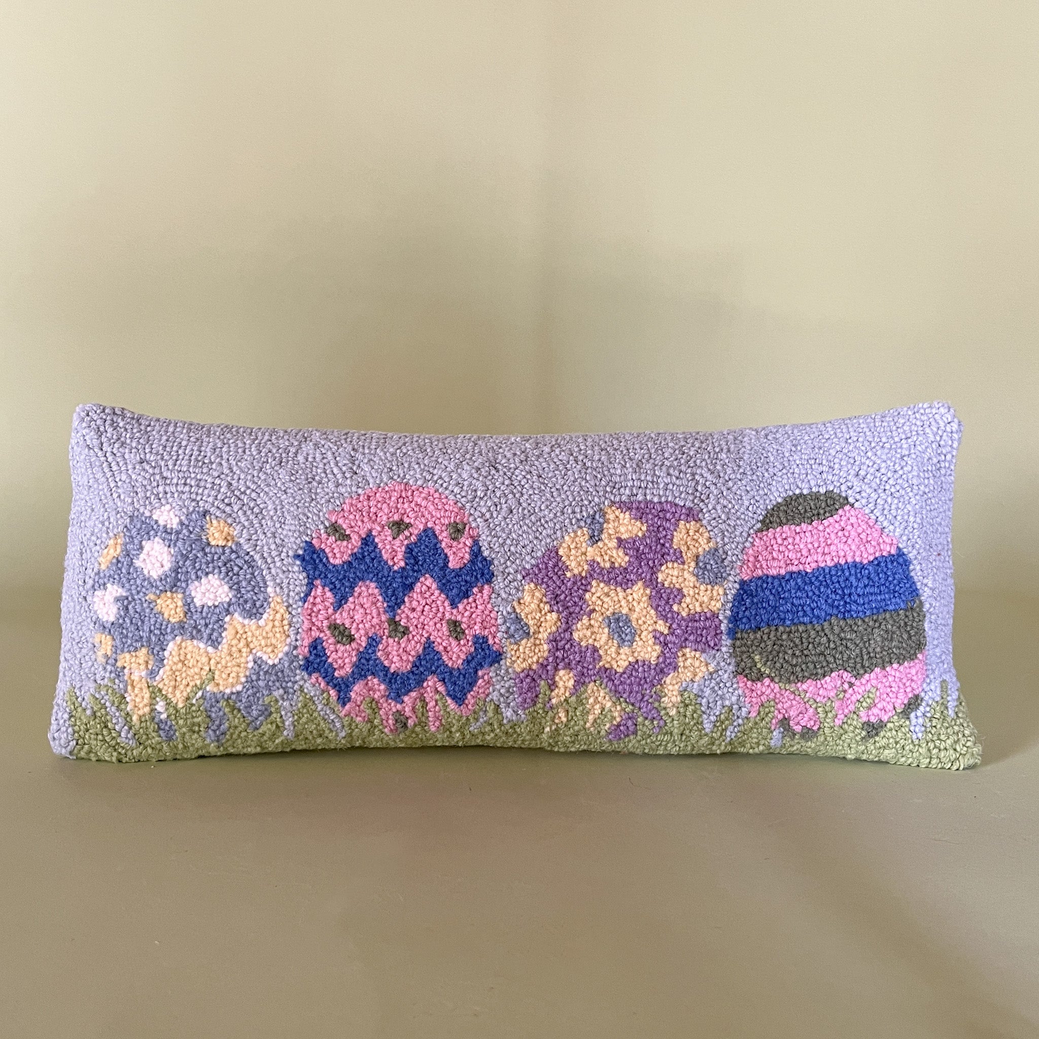 Purple easter pillow with four easter eggs.