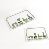 Garden Follies is a rectangular acrylic tray with a white base and green topiary motifs on the bottom border. 