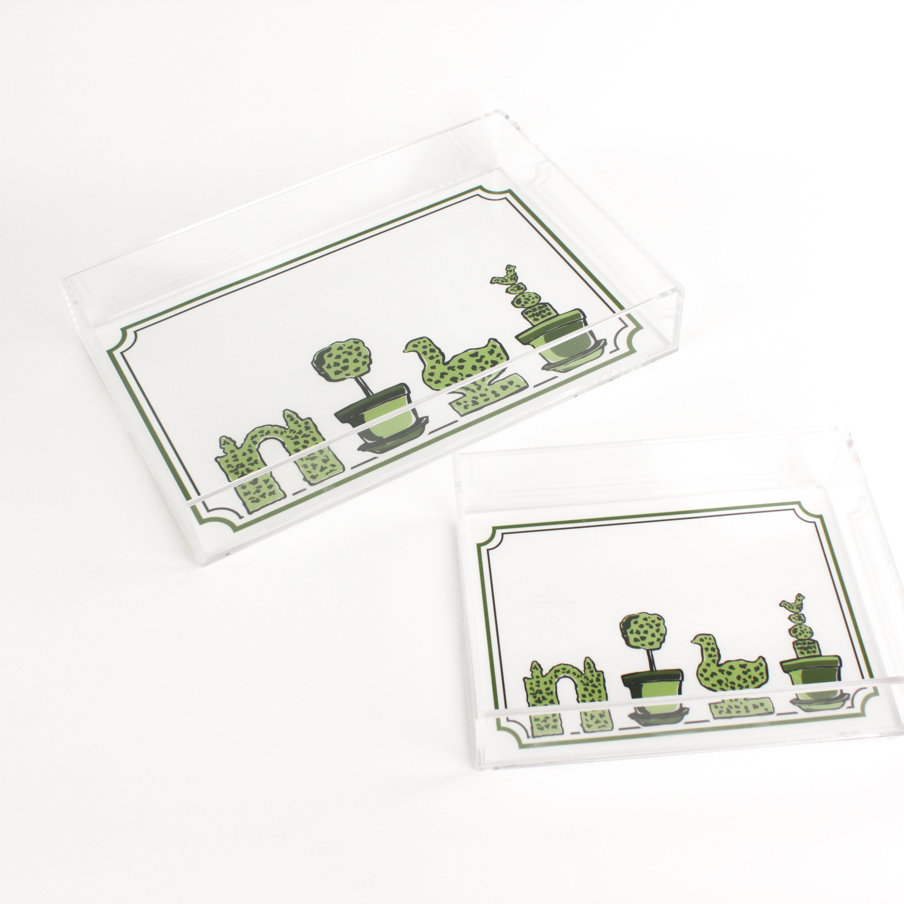 Garden Follies is a rectangular acrylic tray with a white base and green topiary motifs on the bottom border. 