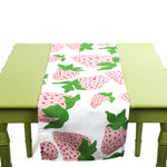 Strawberry-patterned table runner displayed on a green table.
