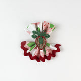 Close-up of folded cloth napkin featuring a strawberry print with red scalloped trim.