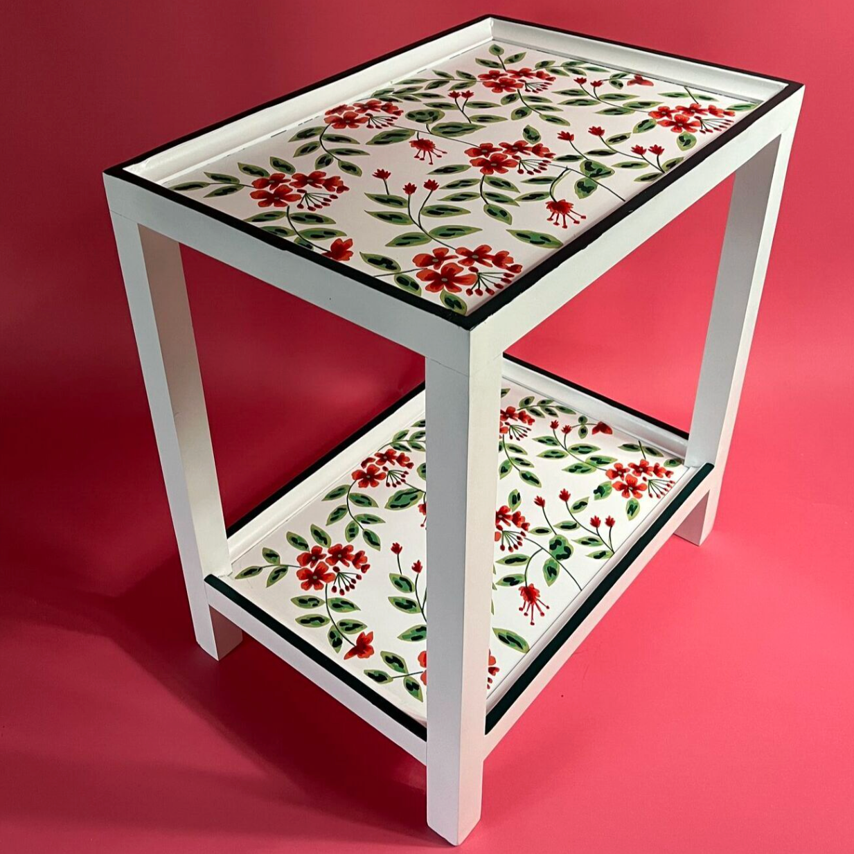 a red, green and white side table painted with red geraniums from madcap cottage