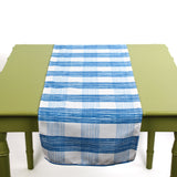 Blue and white checkered table runner displayed on a green table.