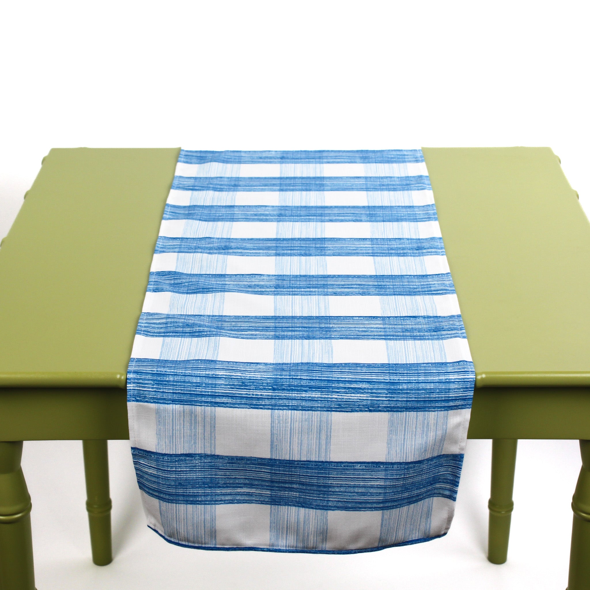 Blue and white checkered table runner displayed on a green table.