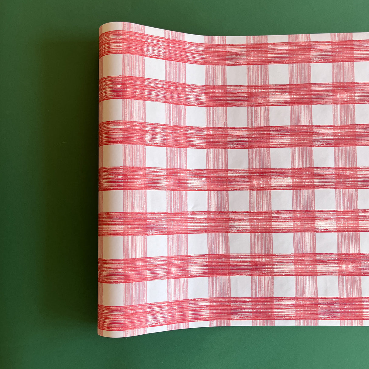 A pink roll of gingham wrapping paper 