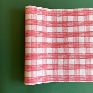 A pink roll of gingham wrapping paper 