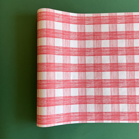 A pink roll of gingham wrapping paper 