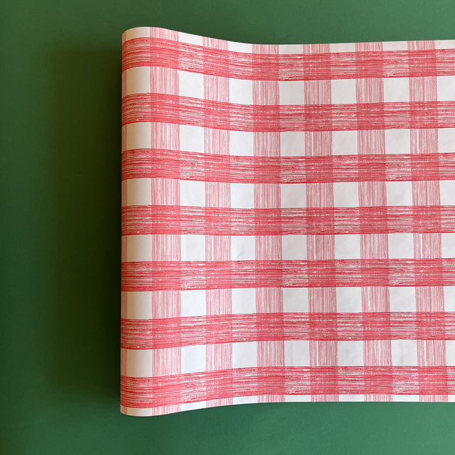 A pink roll of gingham wrapping paper 