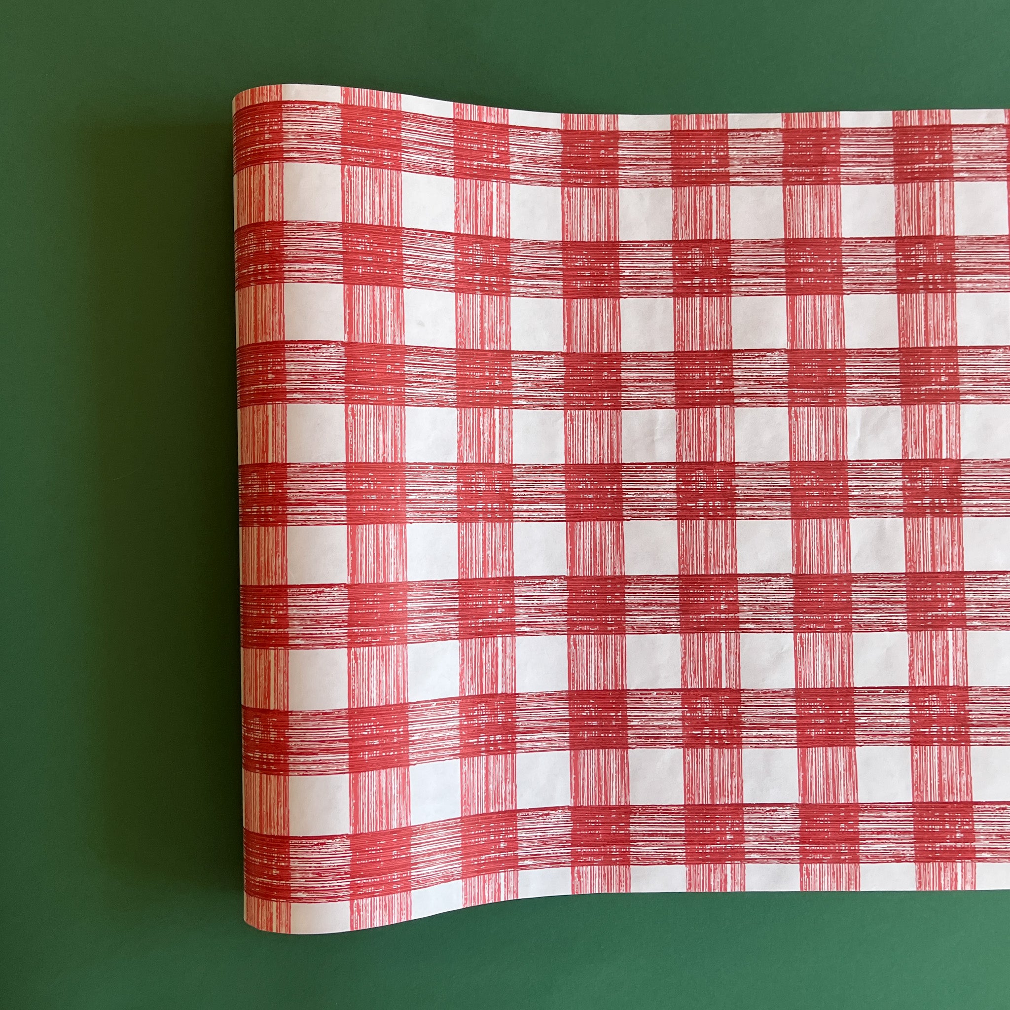 A red roll of gingham wrapping paper 
