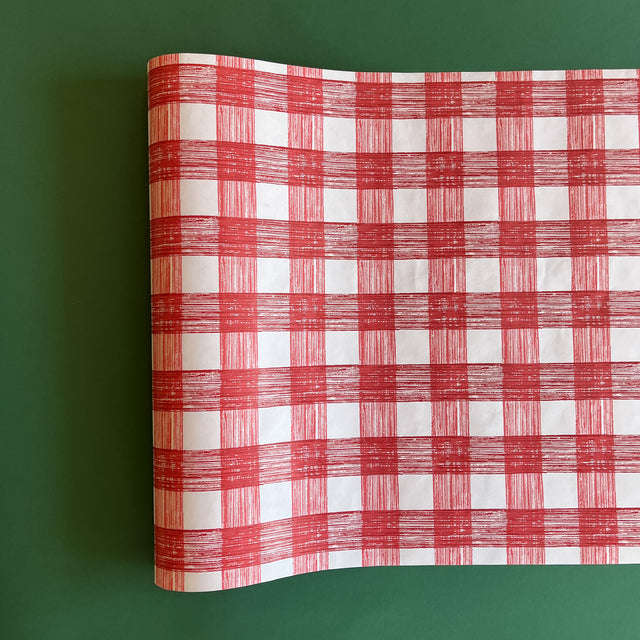 A red roll of gingham wrapping paper 