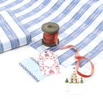 Blue gingham Christmas wrapping paper with ribbon and gift tags on display.