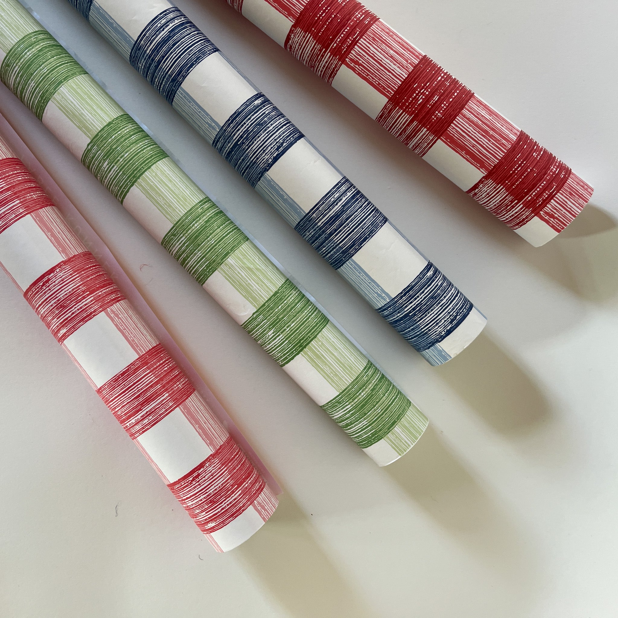 four gingham paper table runners in pink, green, blue and red