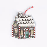 Brown gingerbread house Christmas ornament with a white icing roof, red and white candy cane details, colorful candy accents, and a red and white hanging string.