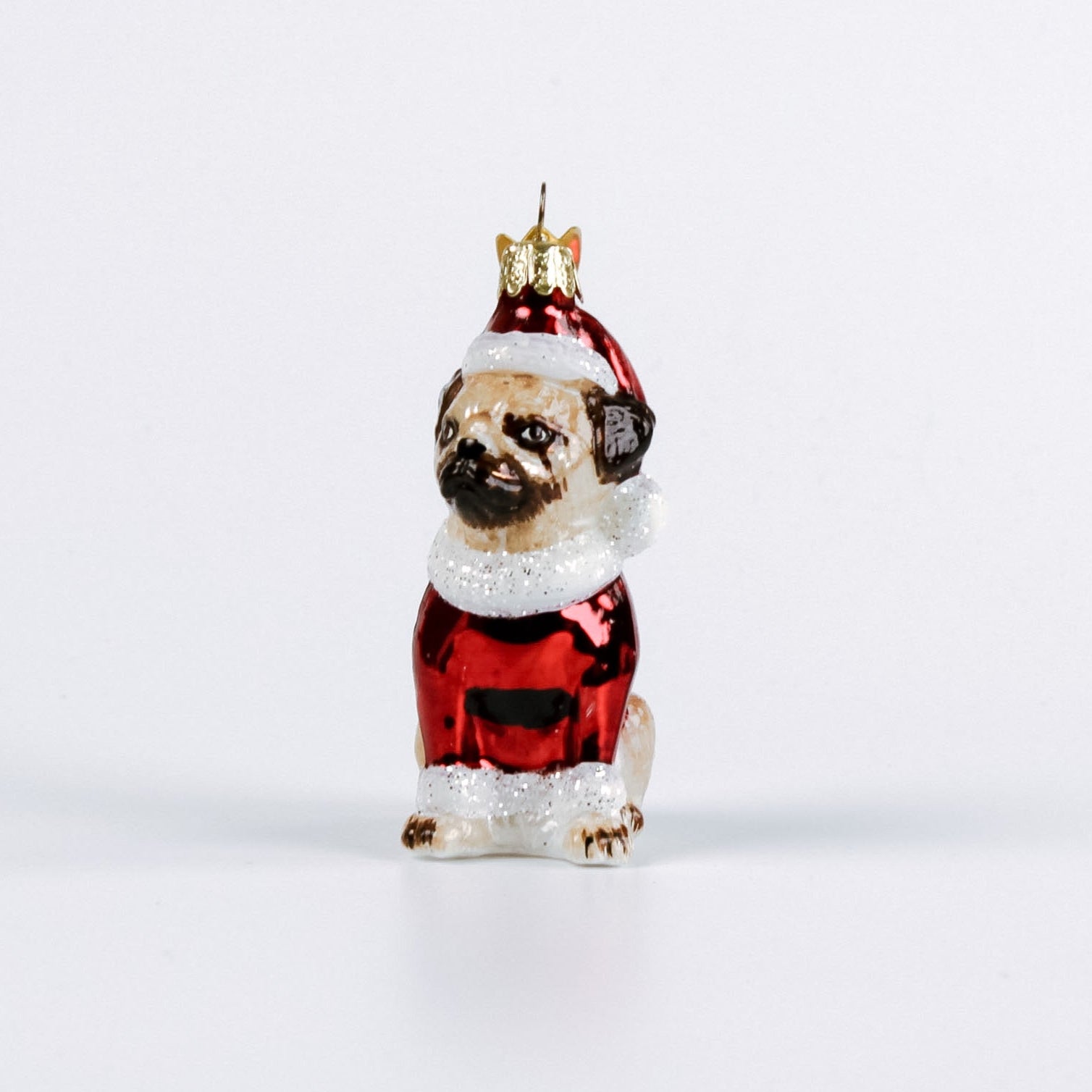Christmas ornament of a pug dog in a Santa outfit on a white background