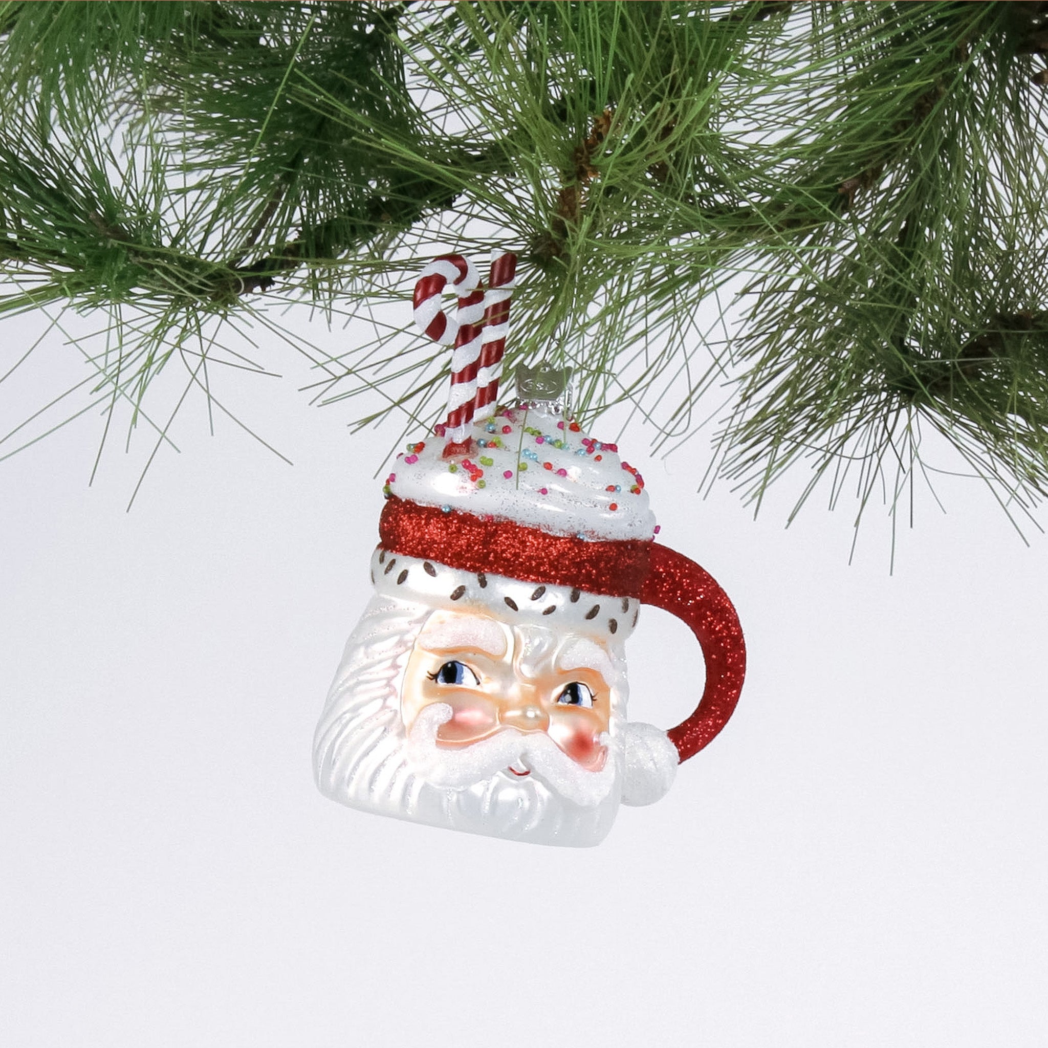 Glass Santa Mug with Glitter Candy Cane Christmas Ornament hanging in a branch
