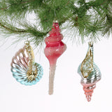 Decorative Christmas tree ornaments with shell design on a branch.