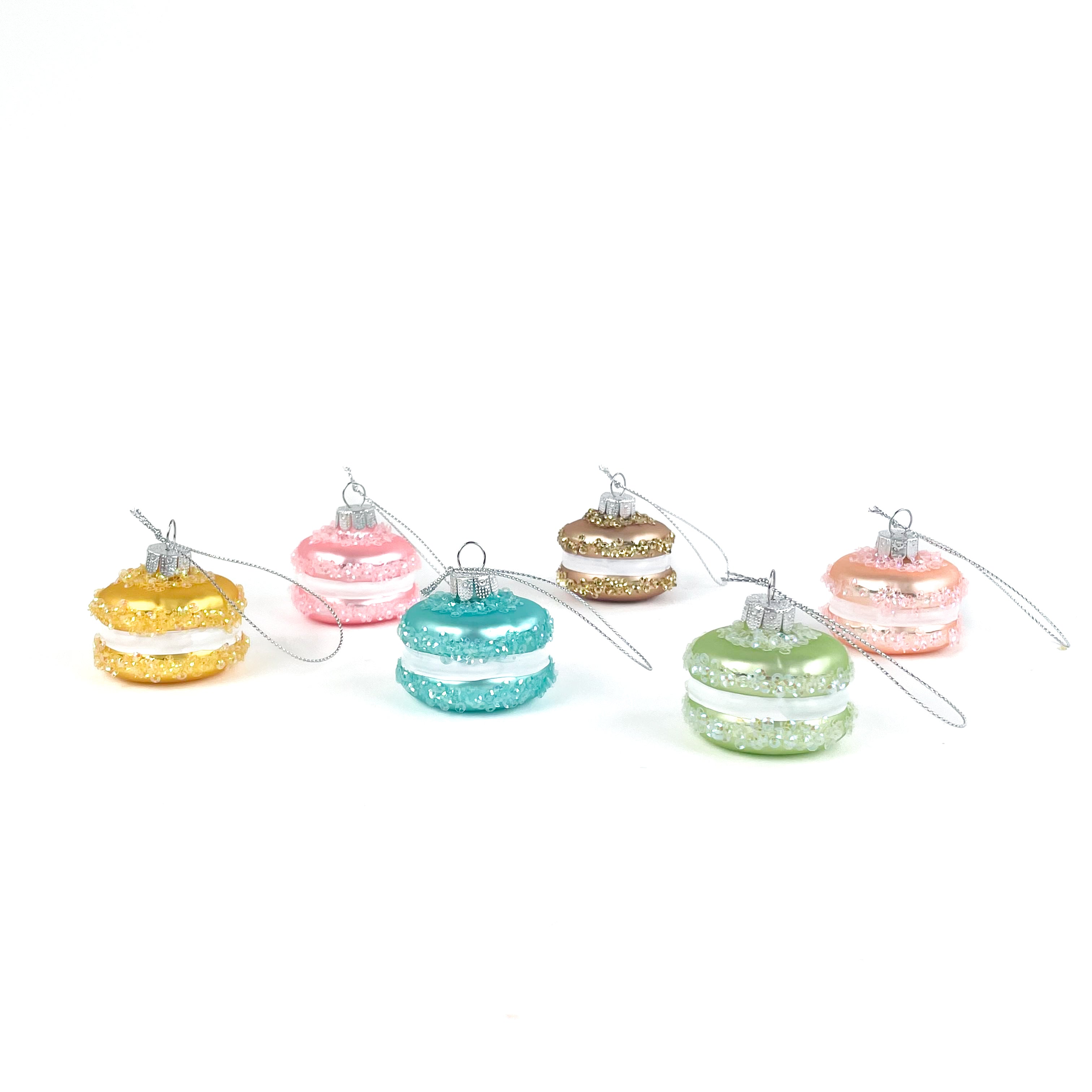 Set of colorful glass macaron ornaments on a white background