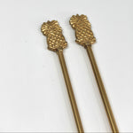 a pair of gold pineapple swizzle sticks from madcap cottage