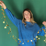 a woman holding a Gold stars Christmas Garland 
