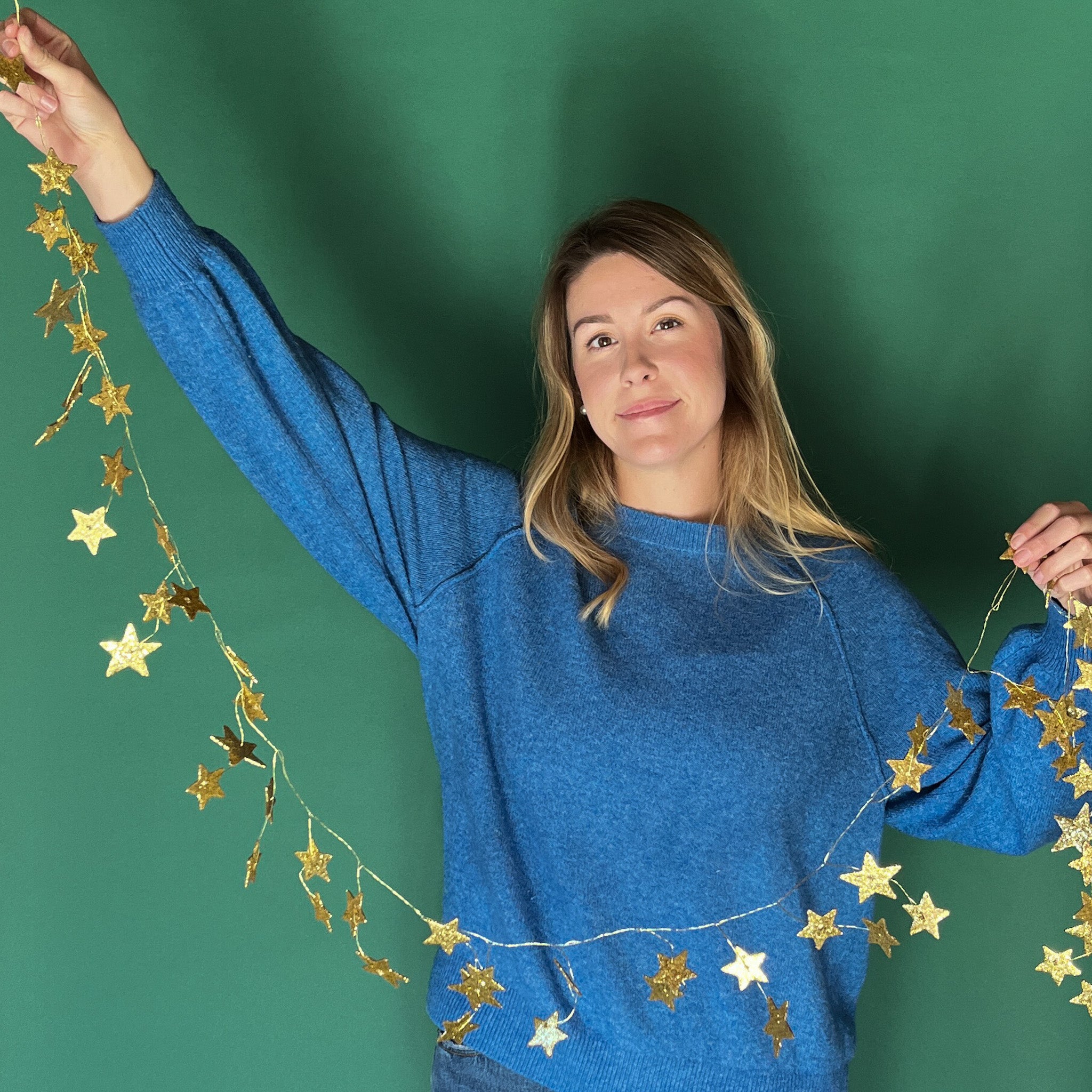 a woman holding a Gold stars Christmas Garland 