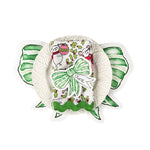 Christmas tabletop display featuring green bow–shaped paper napkins, a white ruffled plate, and a holiday napkin with festive mouse and holly pattern, arranged on a white background.