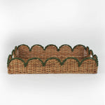 Rattan tray with scalloped edge and green trim on a white background