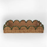 Rattan tray with scalloped edge and green trim on a white background