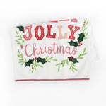 A folded Christmas tea towel with holly motifs and text that reads Holly Jolly Christmas