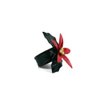 Hand-painted metal poinsettia napkin ring with red petals and green leaves on a white background.