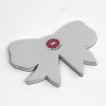 Back view of a bow-shaped tray showing the plain finish and maker label.