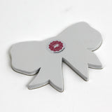 Back view of a bow-shaped tray showing the plain finish and maker label.